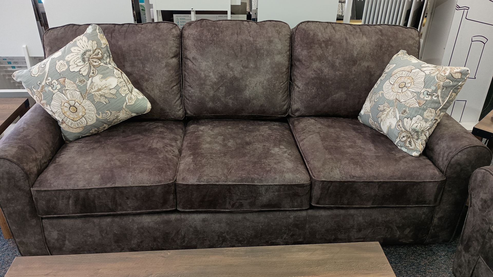 A brown couch with two pillows on it