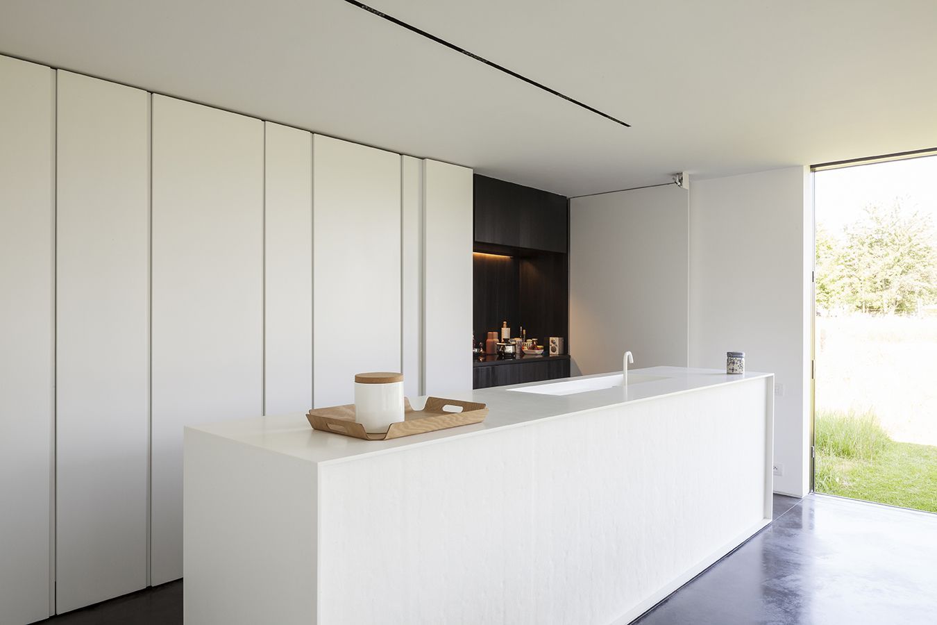 A kitchen with white cabinets and a large island