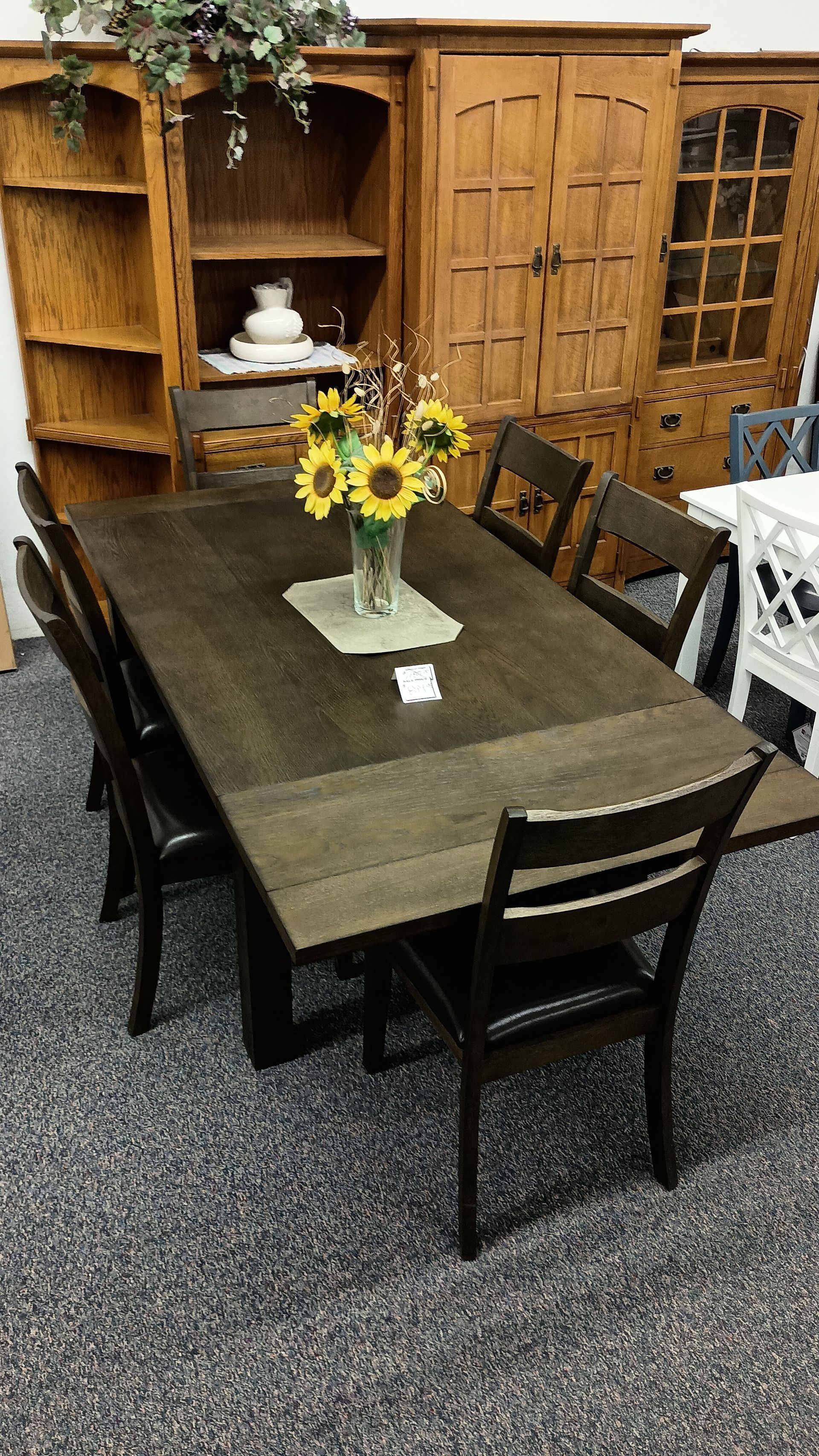 A table with a vase of sunflowers on it