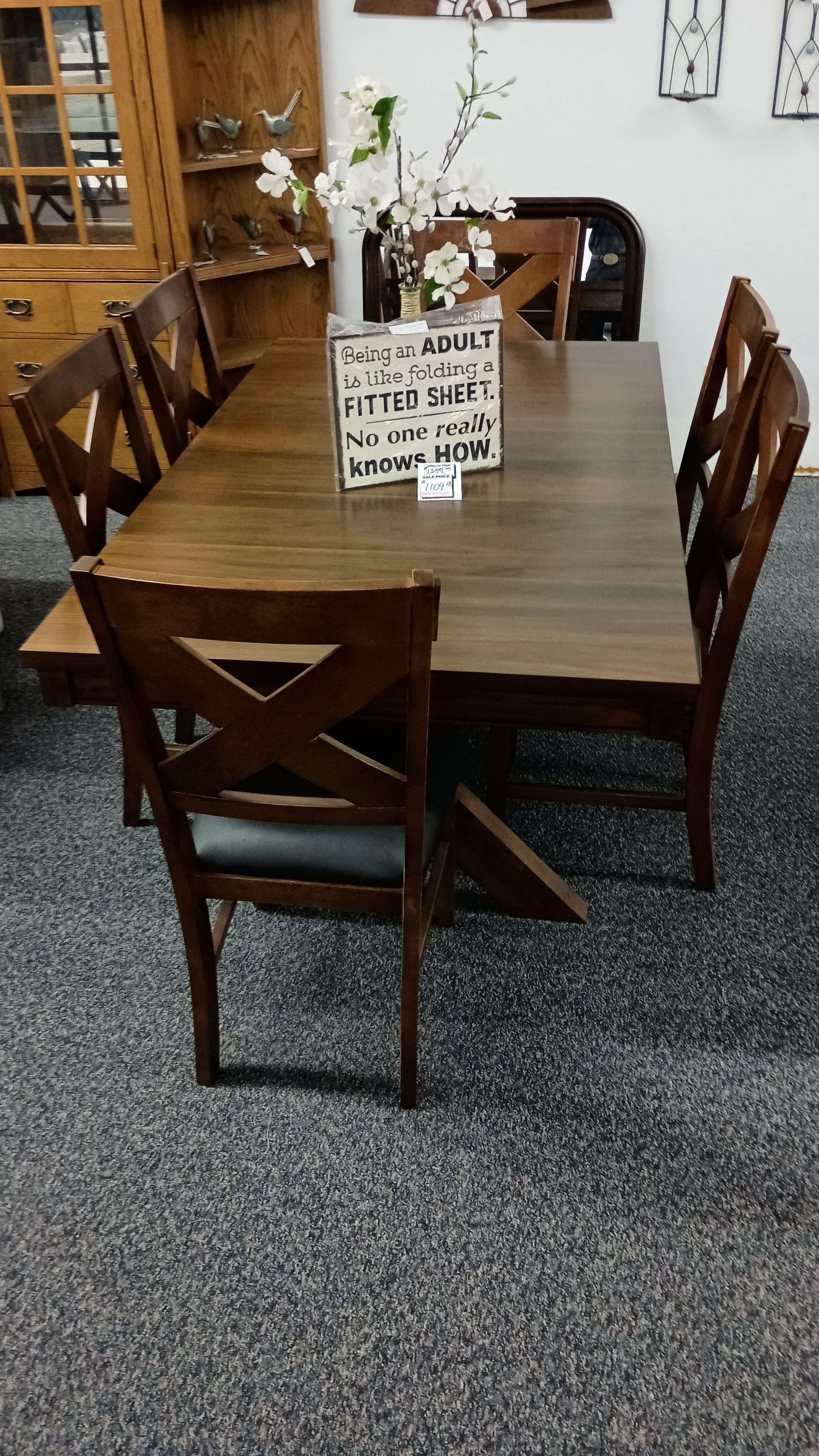A dining room table with a vase of flowers on it