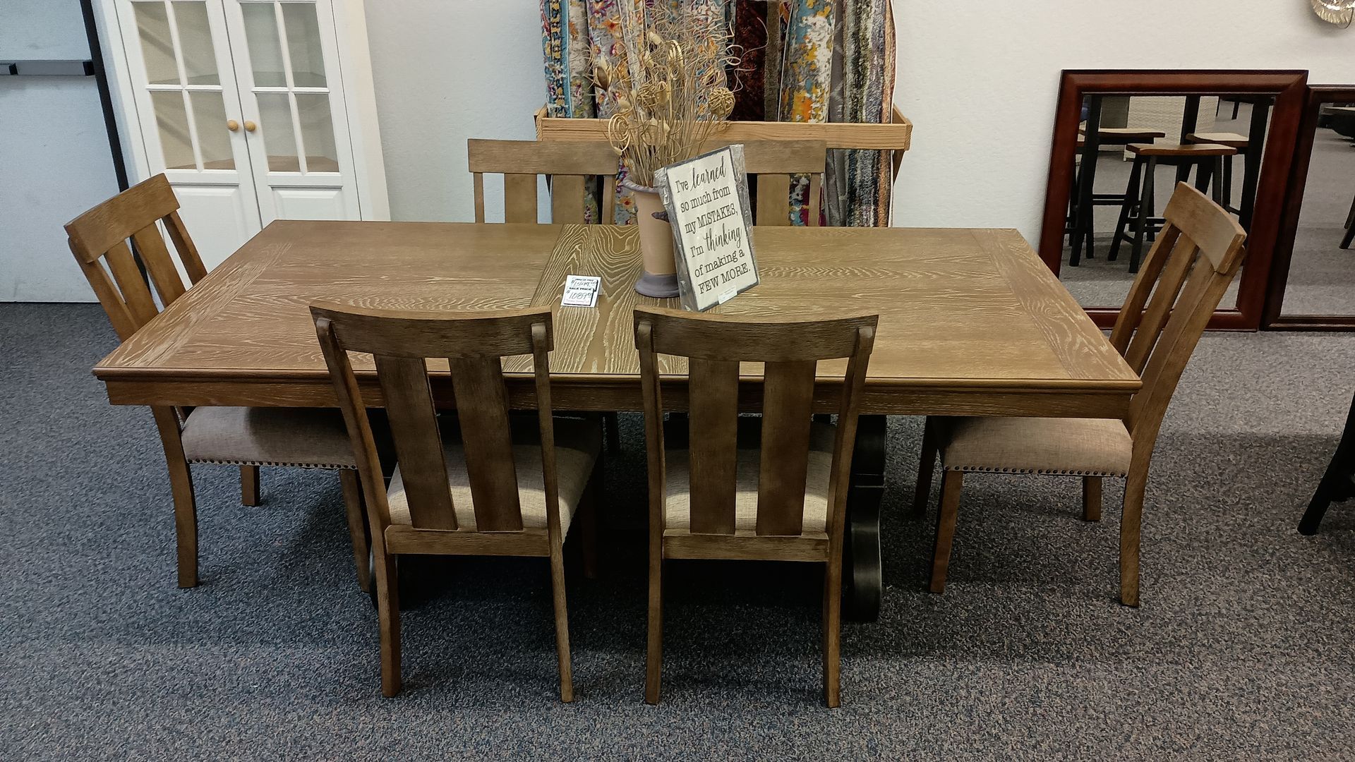 A dining table with chairs and a vase of flowers on it