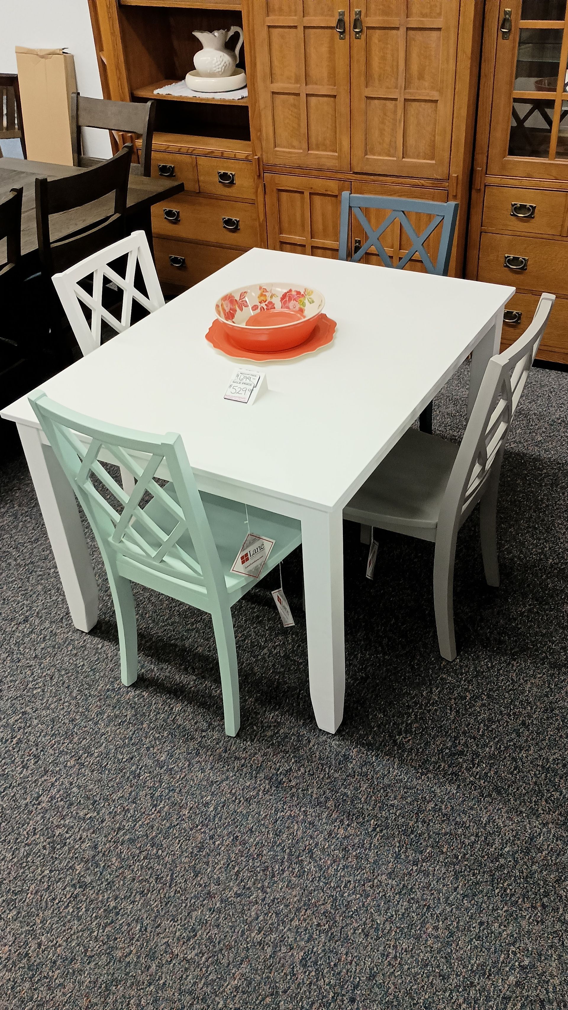 A white table with a red bowl on top of it