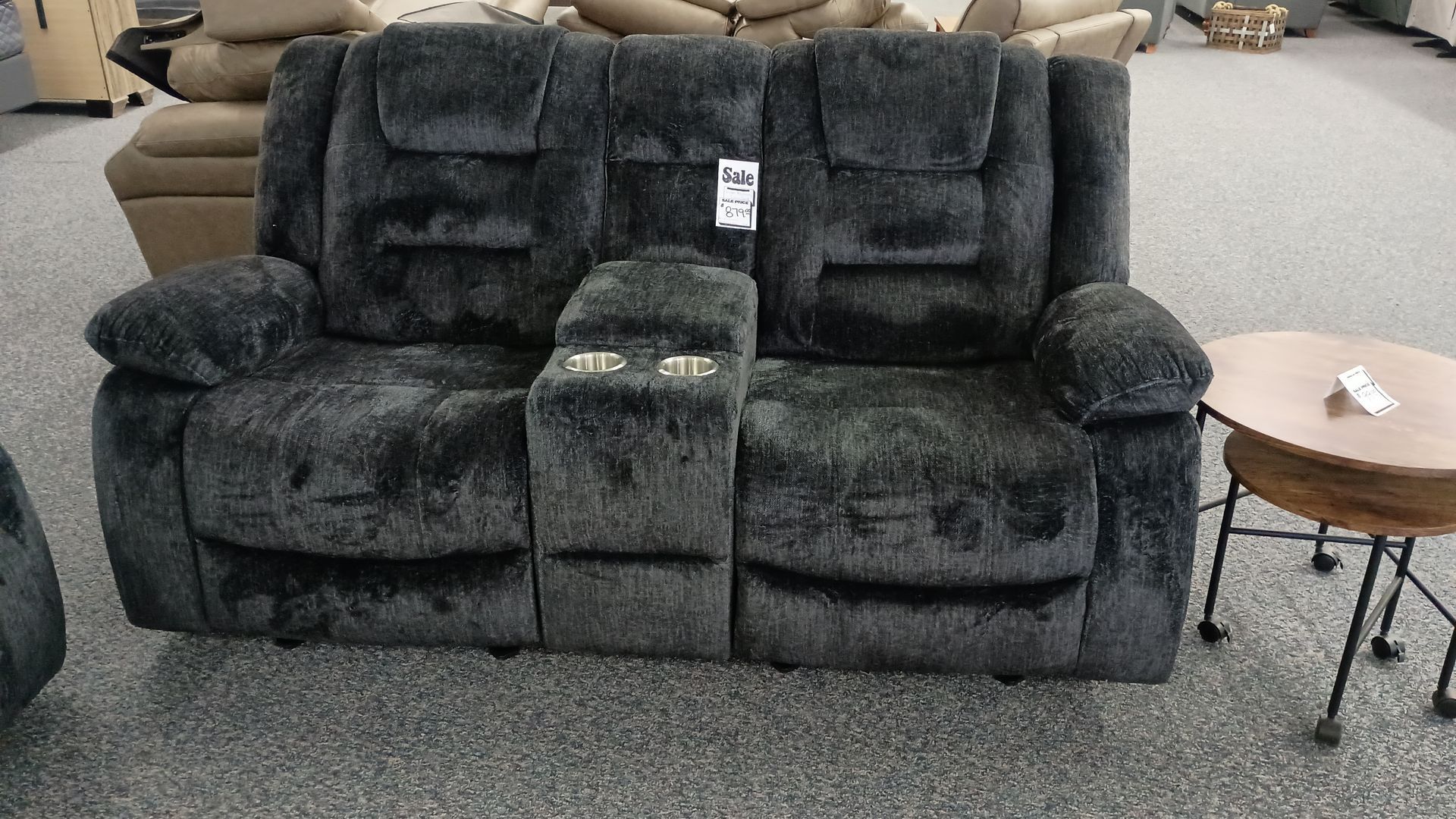 A black couch with a price tag on it