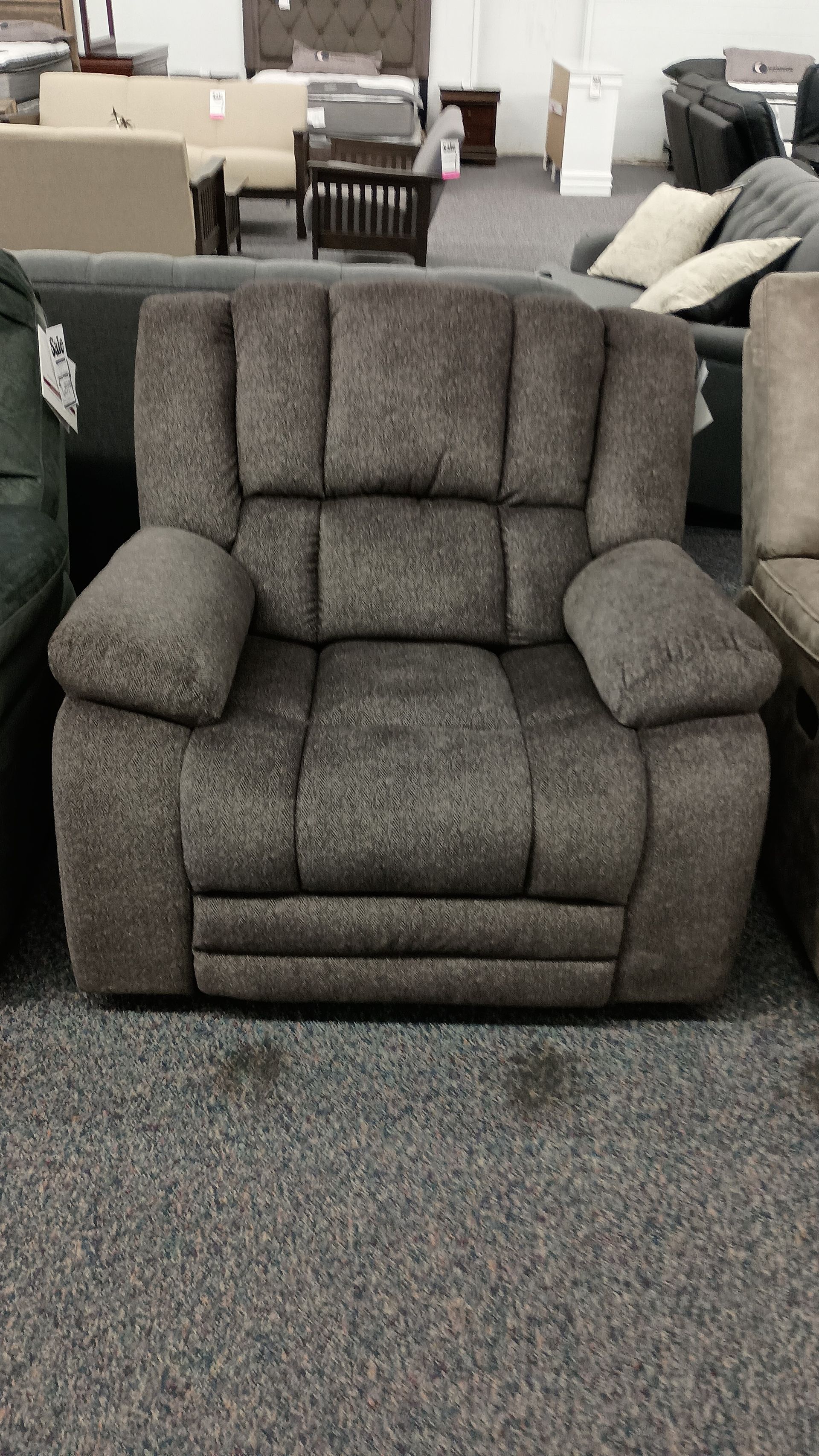 A recliner is sitting in a room filled with furniture.