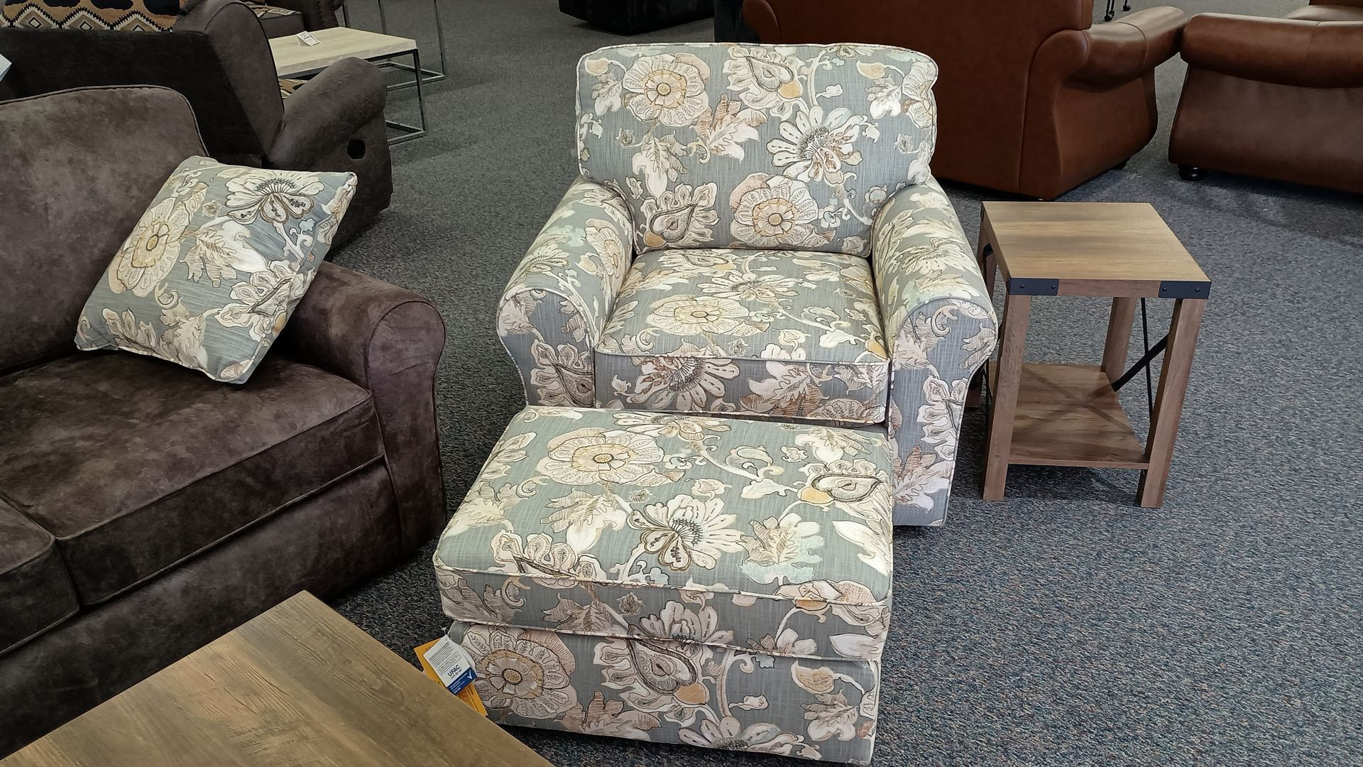 A chair with a floral pattern sits next to an ottoman