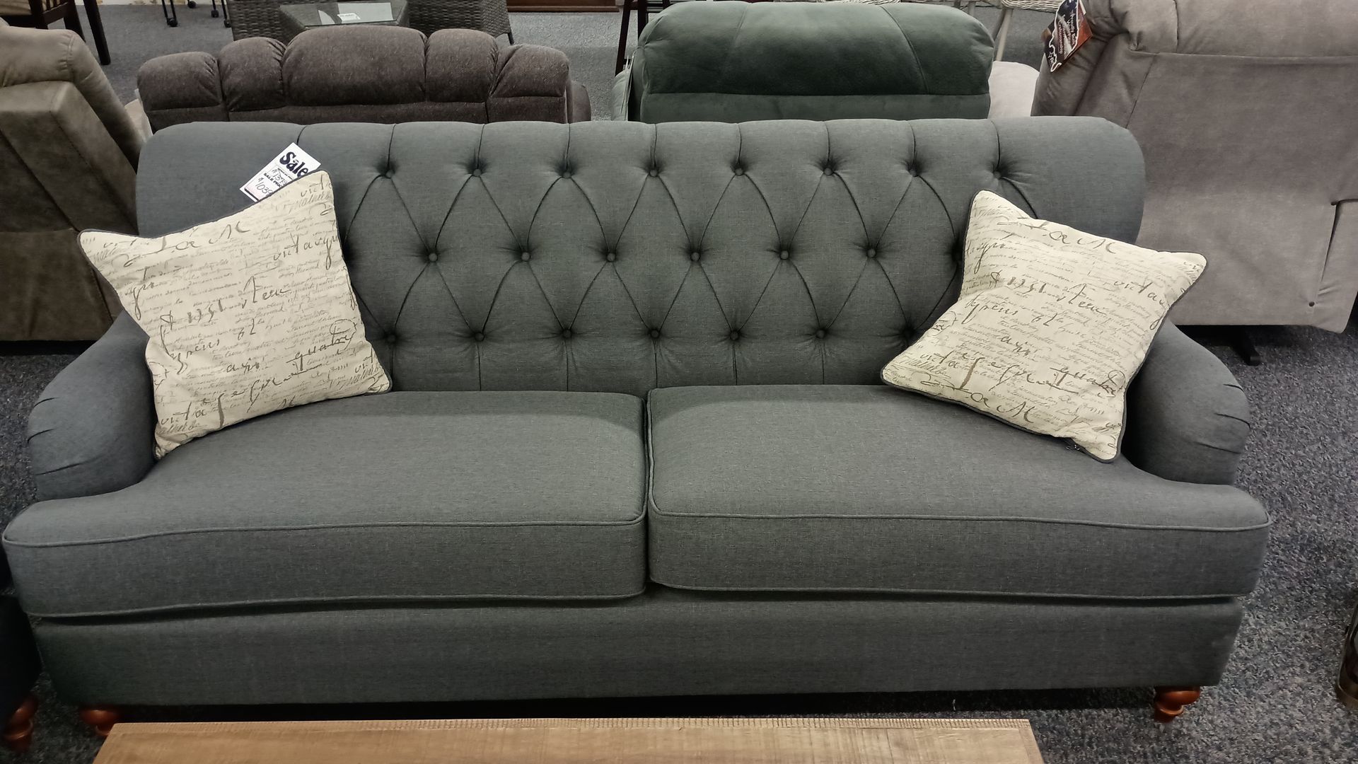 A grey couch with two white pillows on it