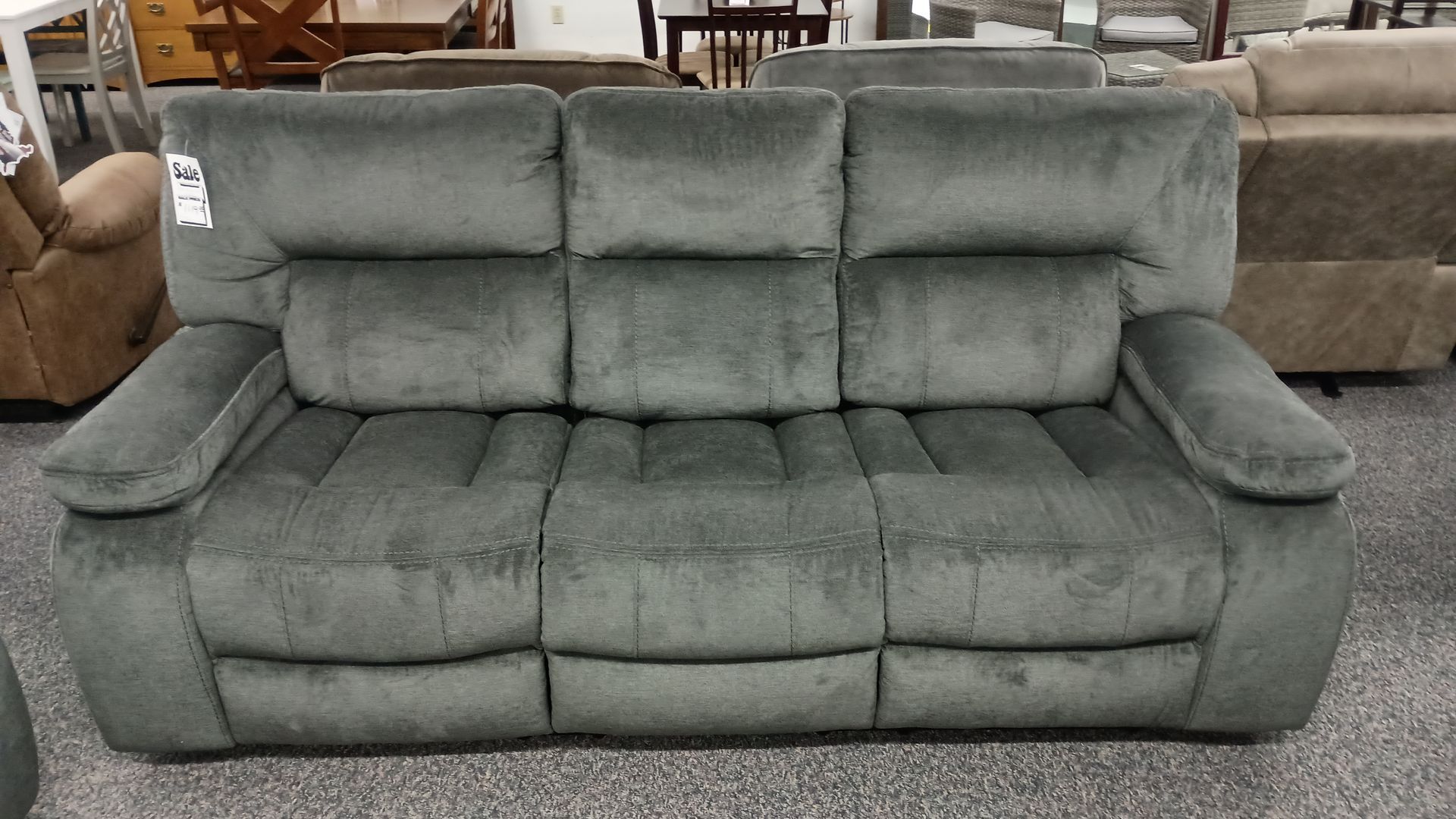 A grey recliner couch is sitting in a living room
