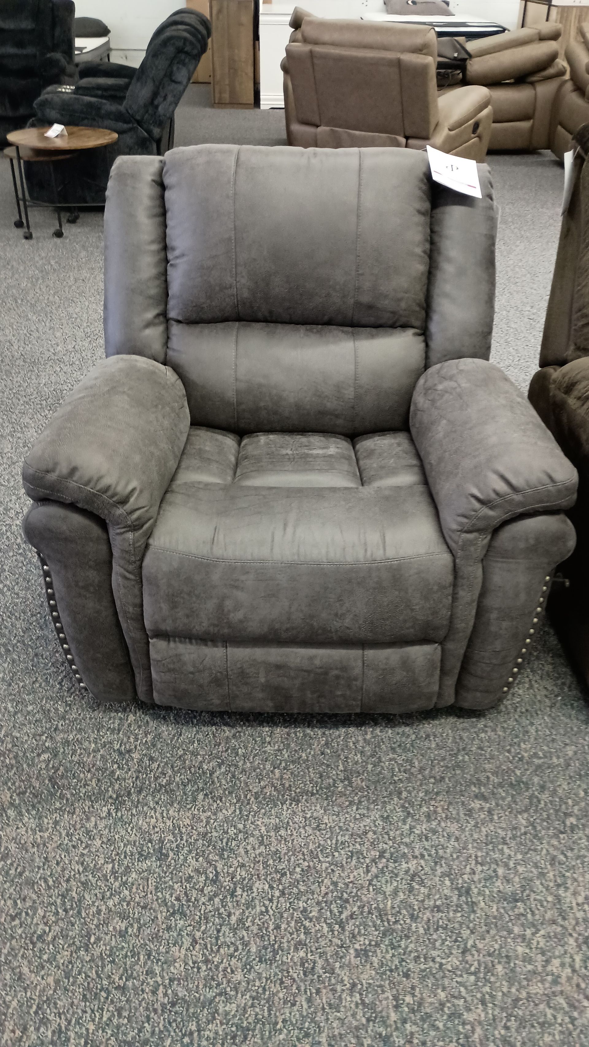 A recliner is sitting on a carpeted floor in a room.