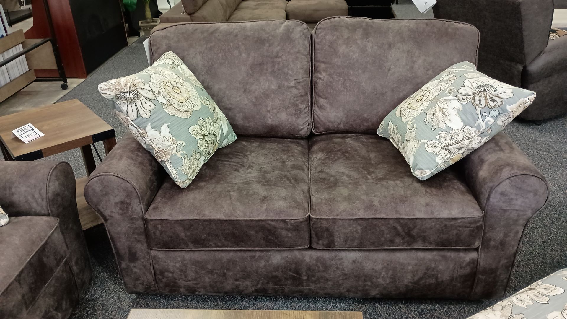 A brown couch with two pillows on it