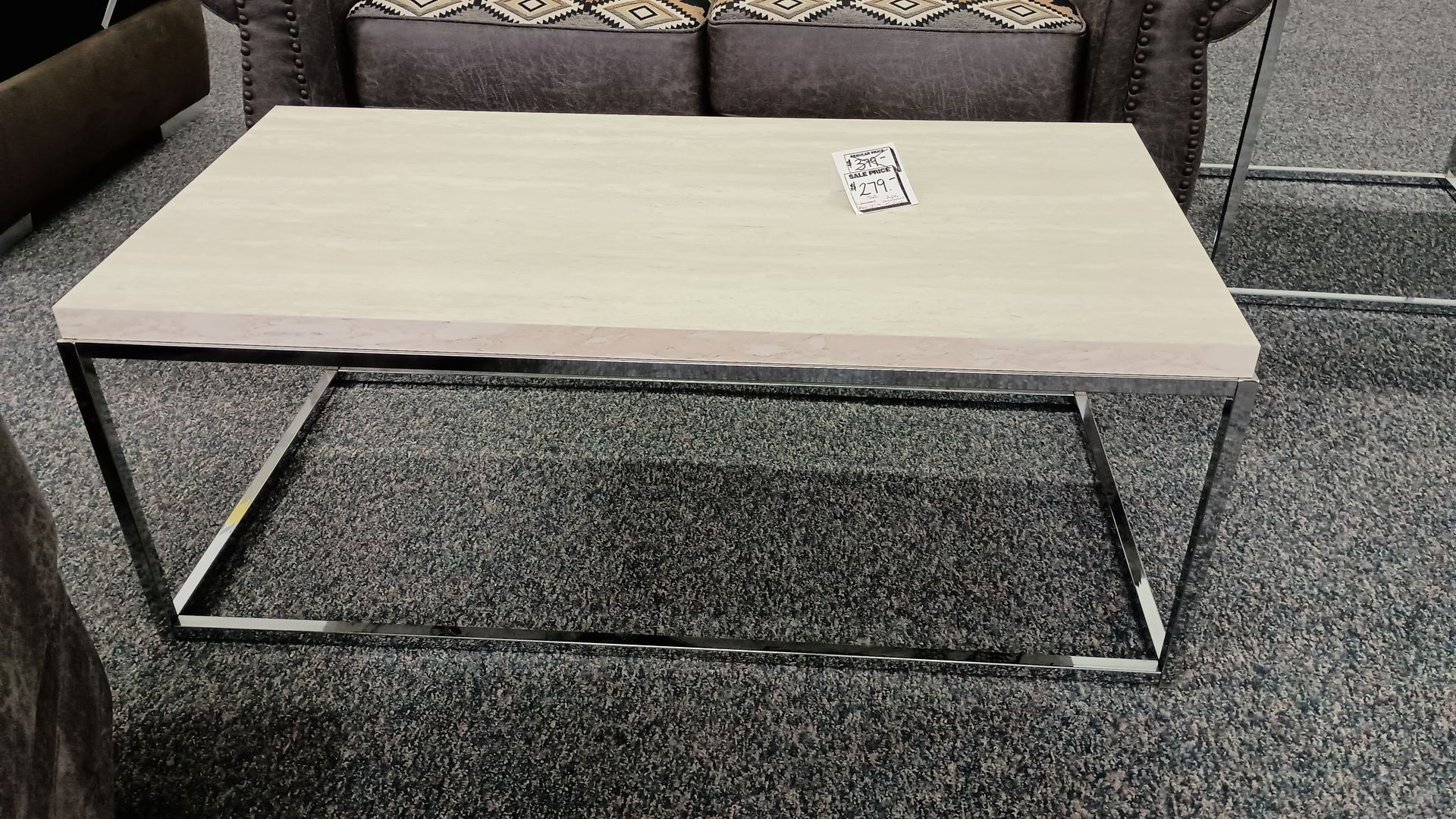 A coffee table is sitting on a carpet next to a couch.
