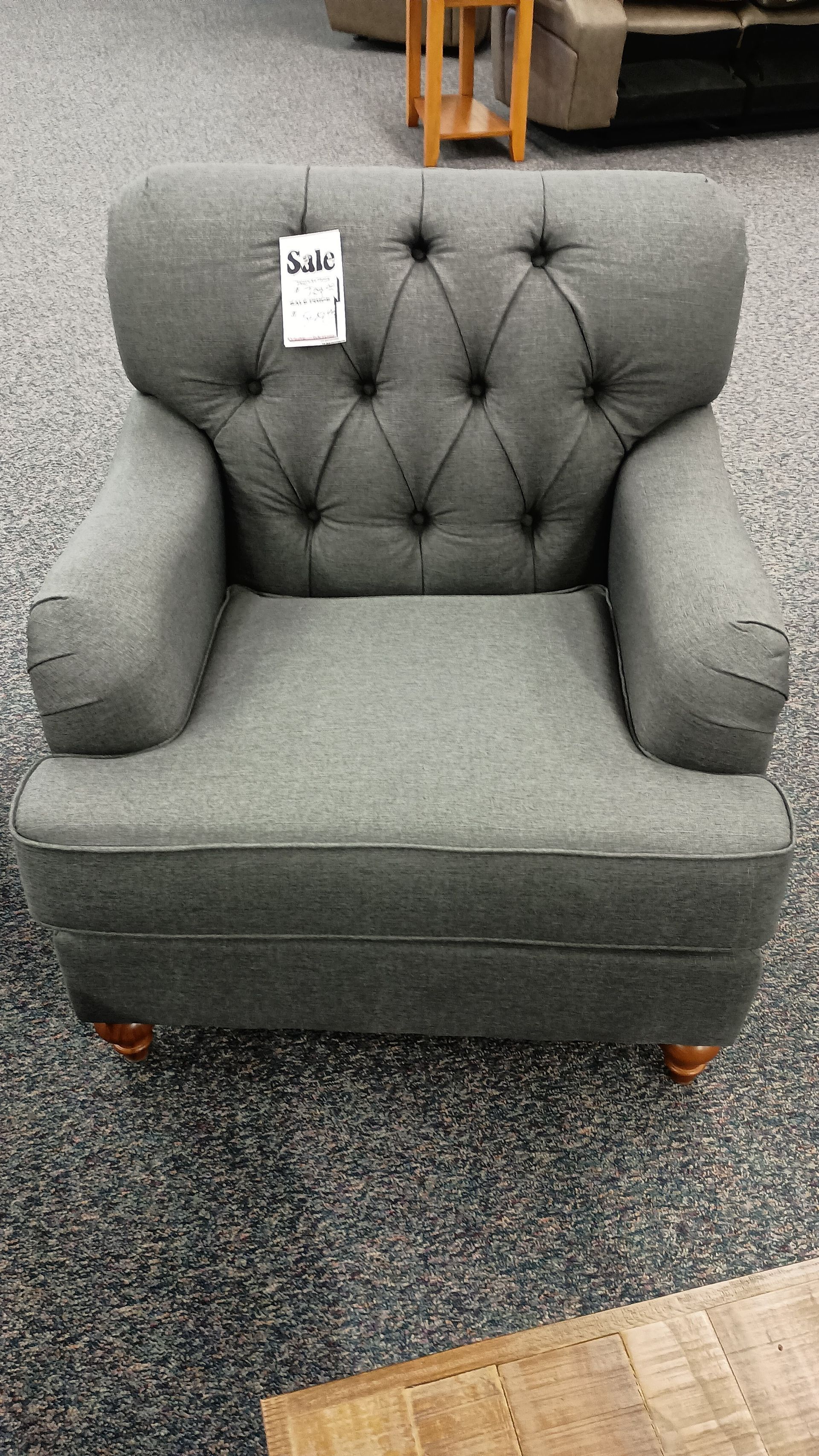 A grey chair with a tag that says 64 on it
