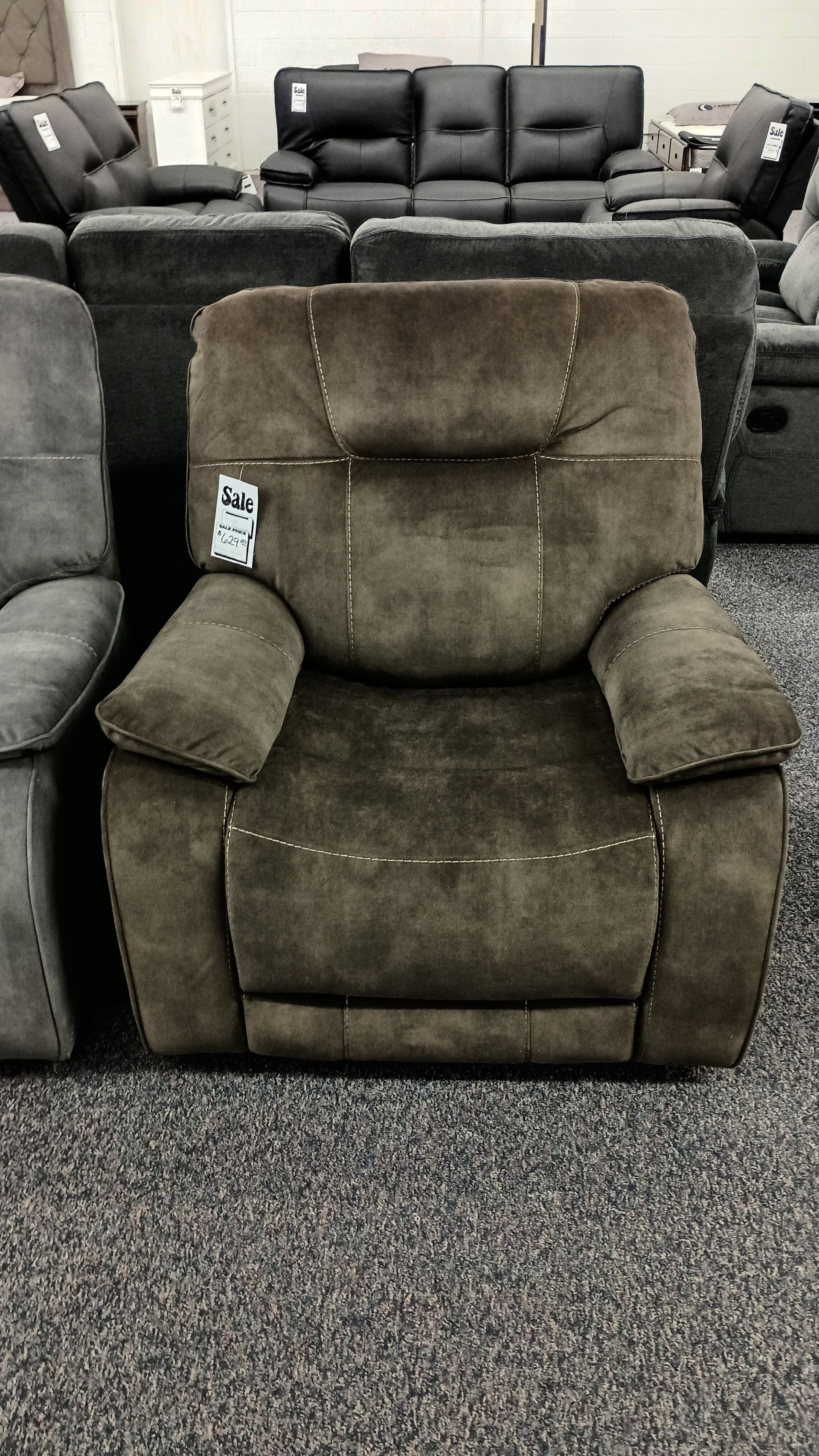 A brown recliner is sitting on a carpeted floor in a living room.