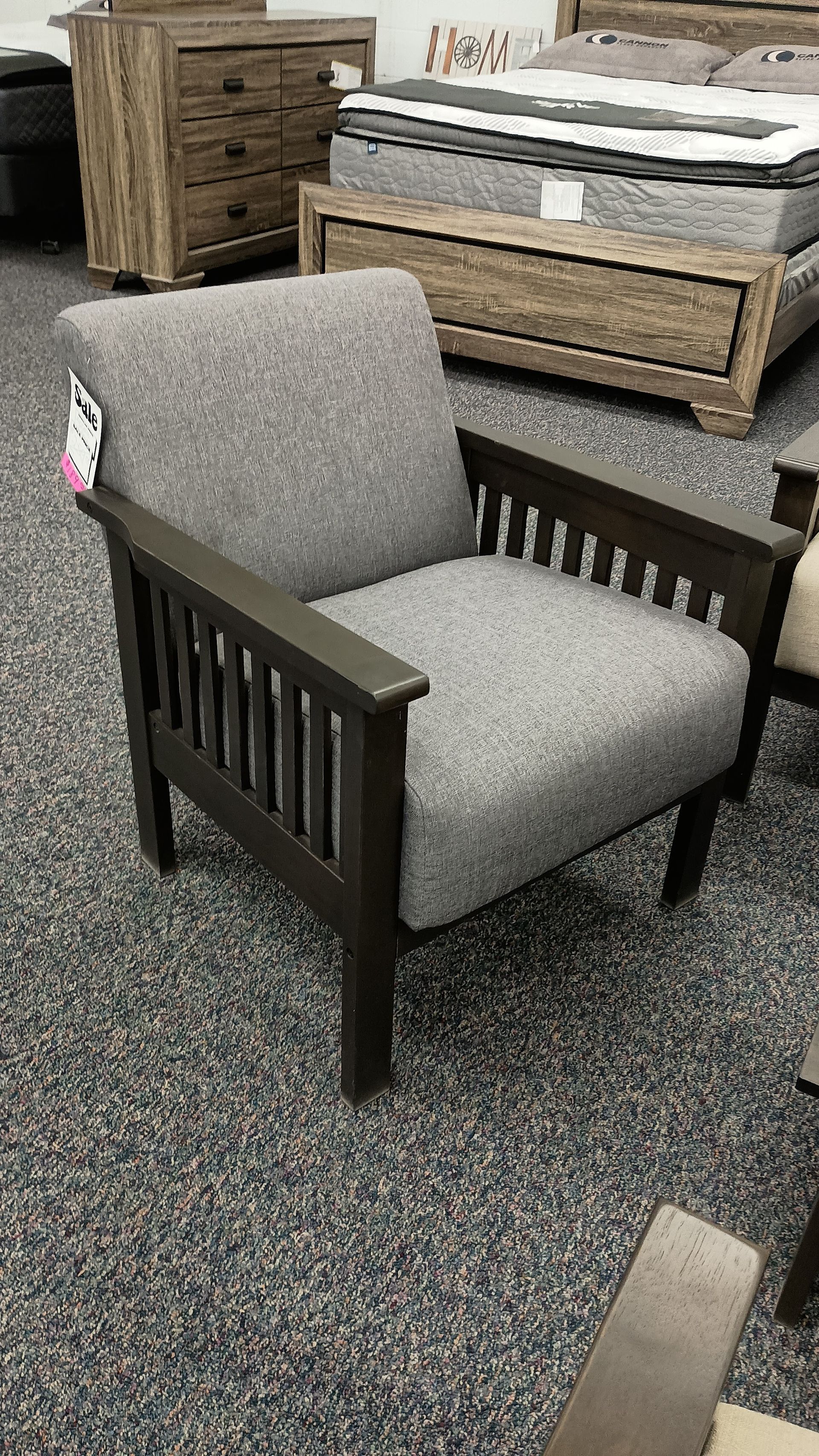 A chair is sitting on a carpeted floor next to a bed.