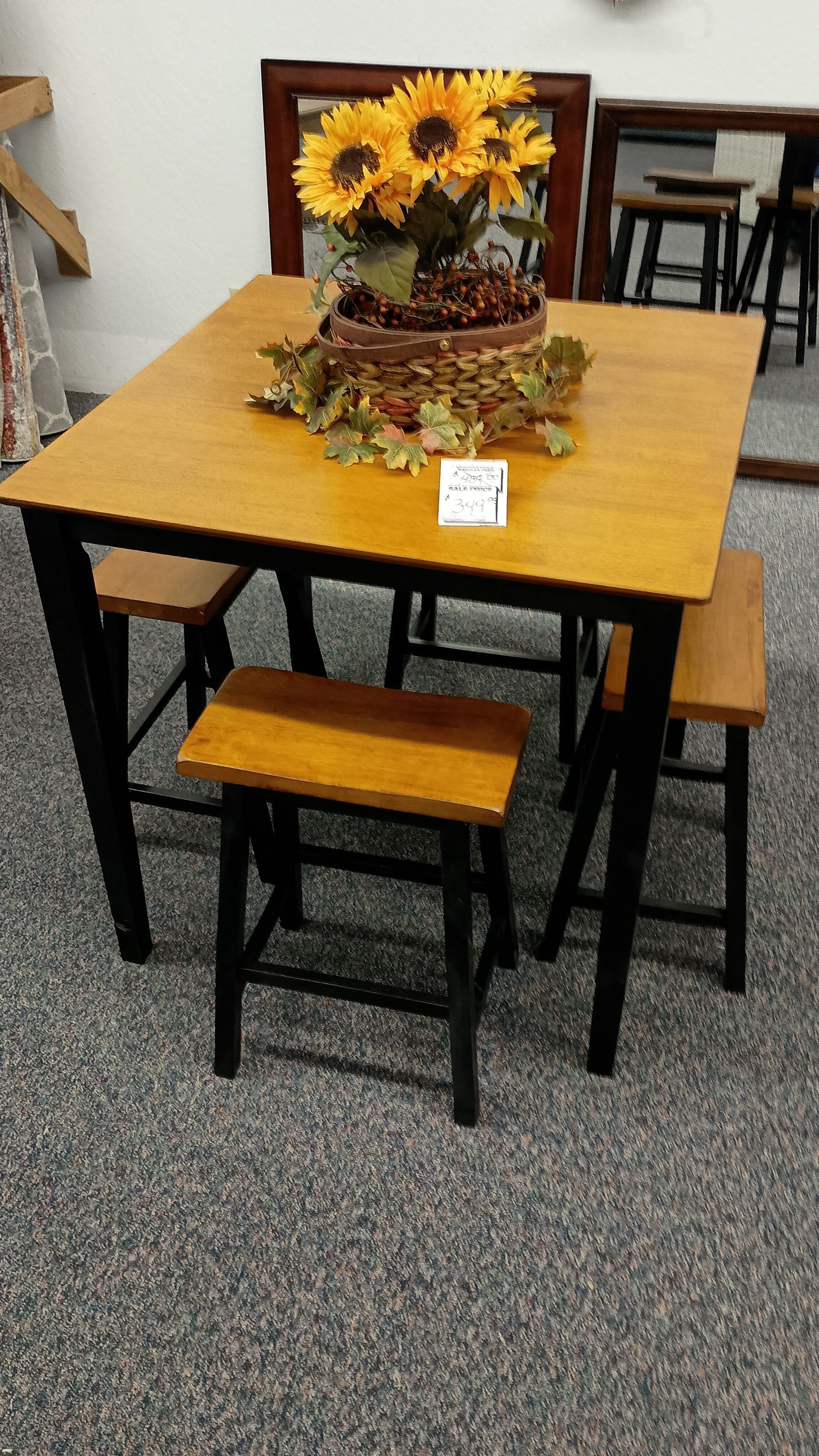 A table with a vase of sunflowers on top of it