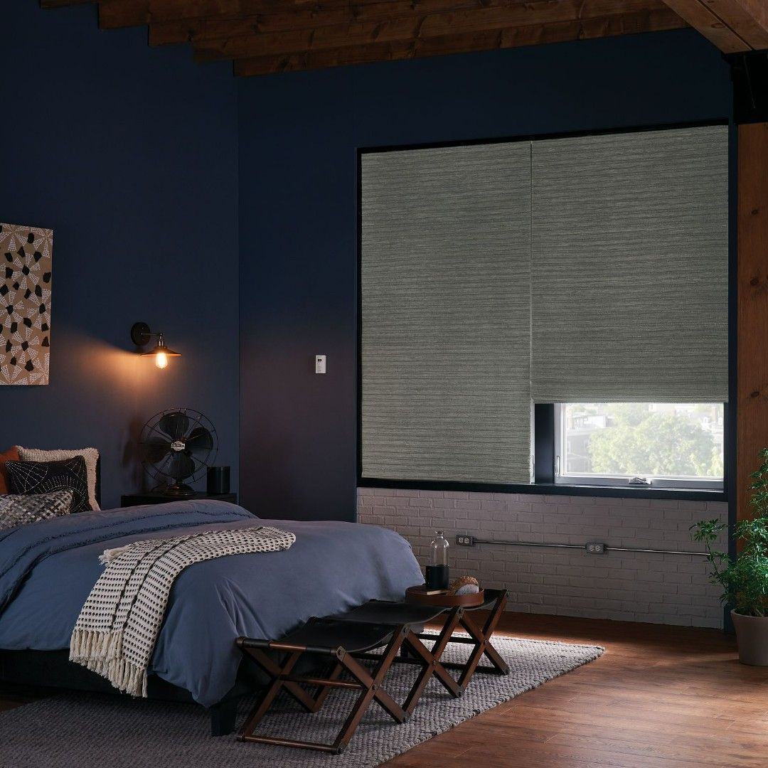 A bedroom with a bed and a window with blinds