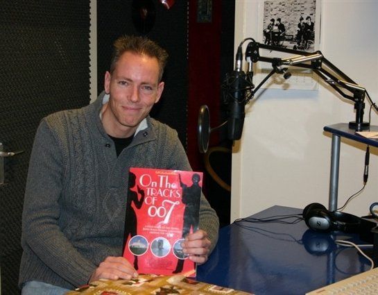 Martijn Mulder posing with his book 'On the gtracks of 007' in a radio studio
