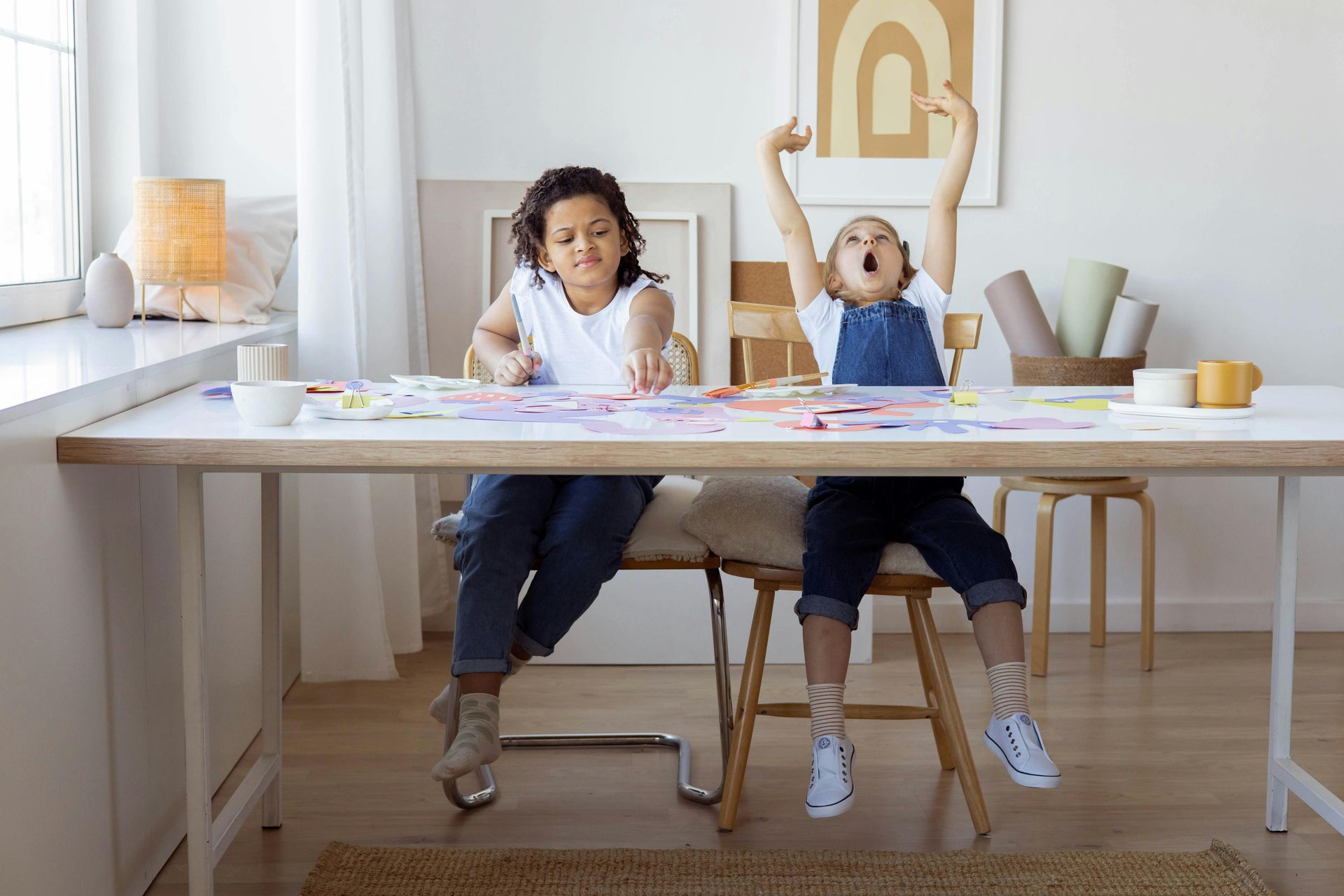 A young child yawning while sitting at the table.