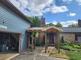 A house with a porch and a garage next to it.