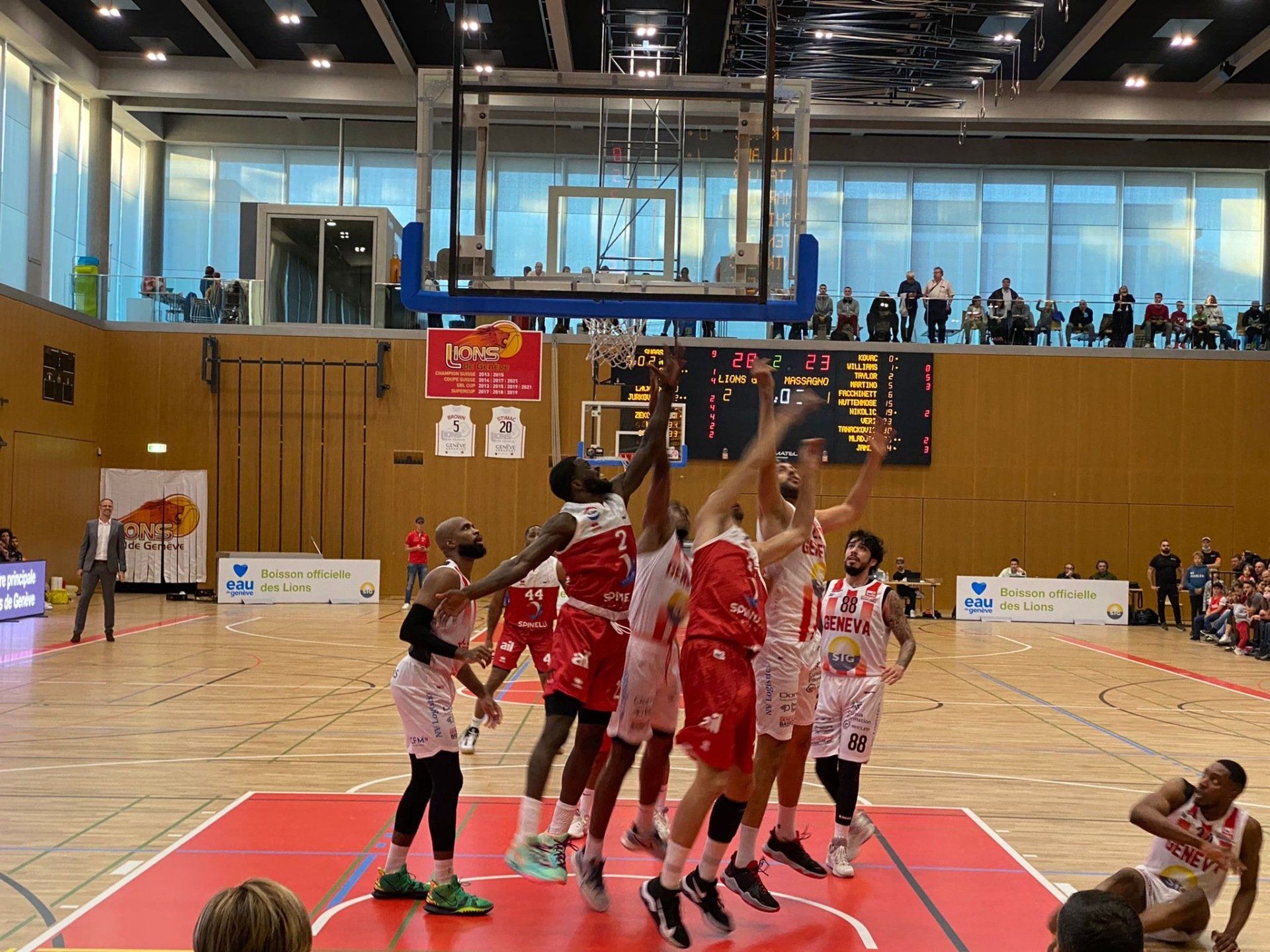 Un groupe de joueurs de basket-ball joue à un jeu sur un terrain.