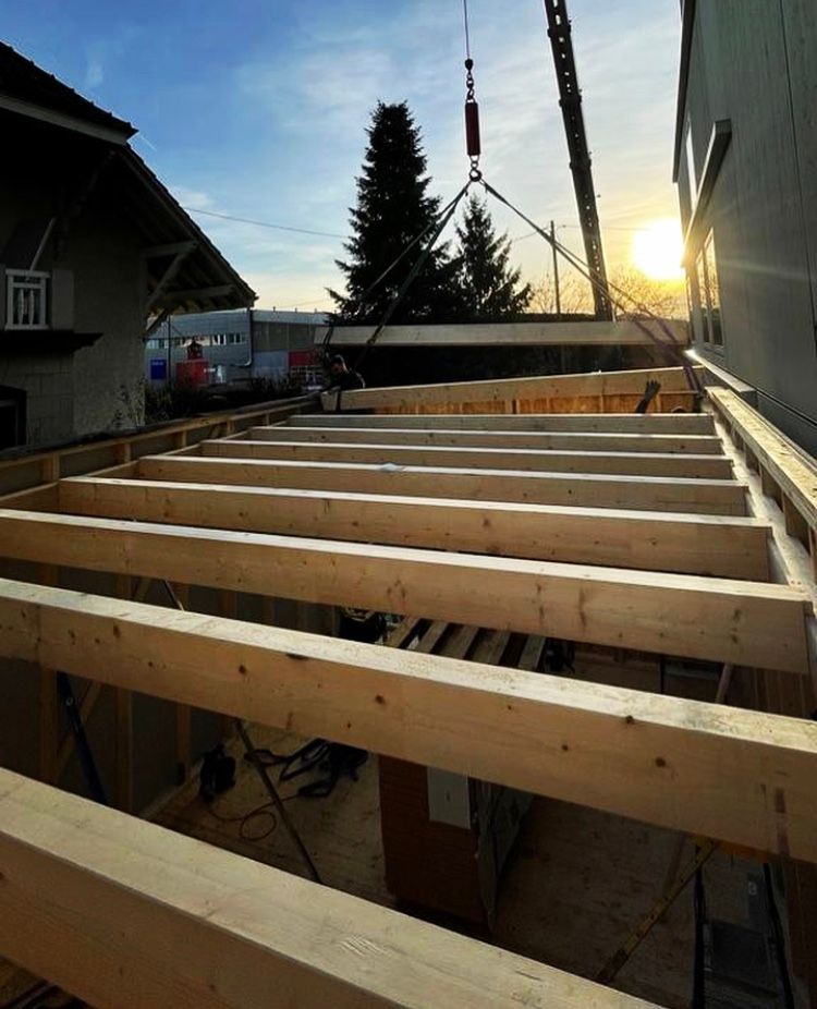 Une grue soulève une structure en bois en place