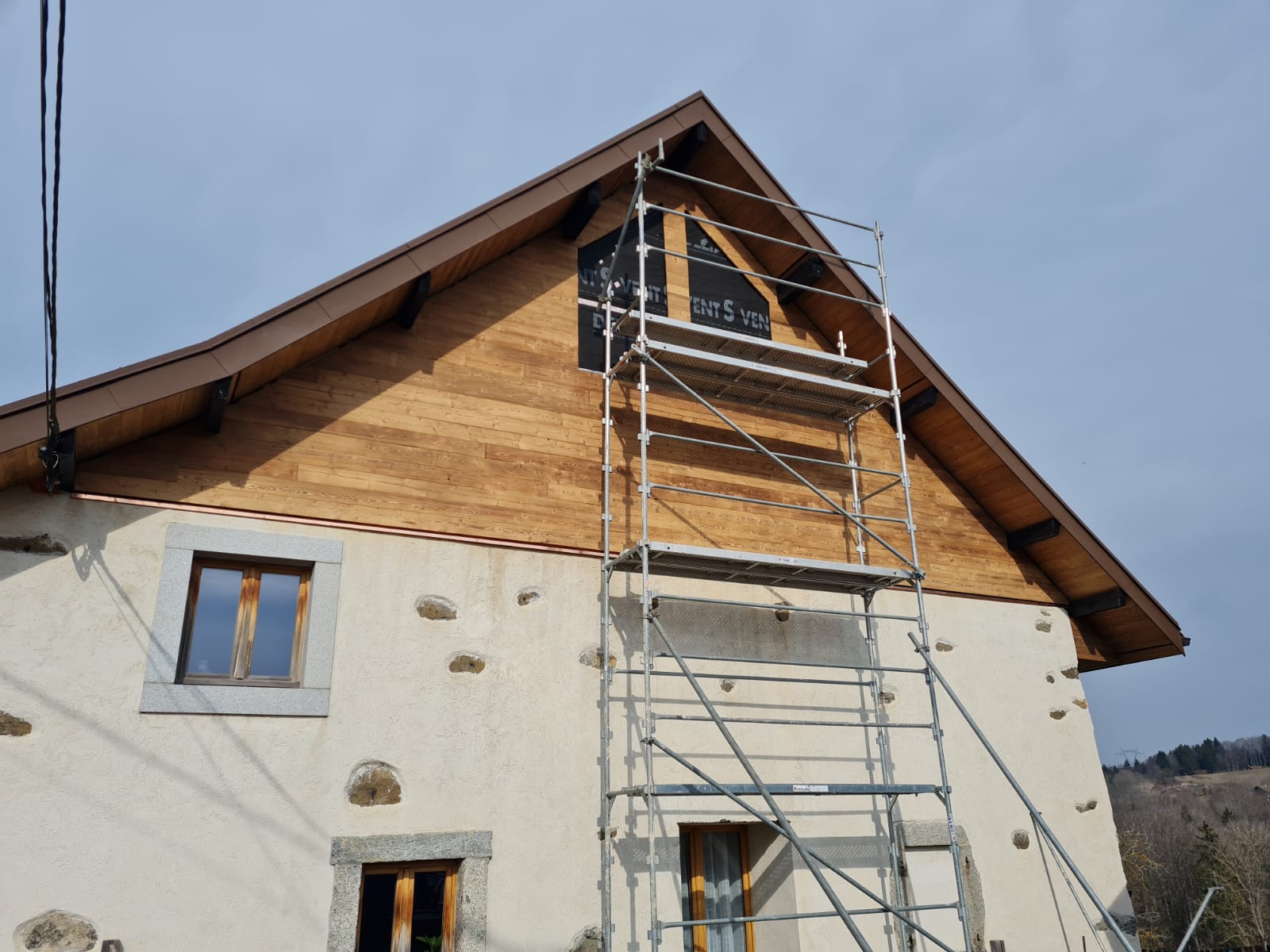 Une maison blanche avec un échafaudage sur le côté