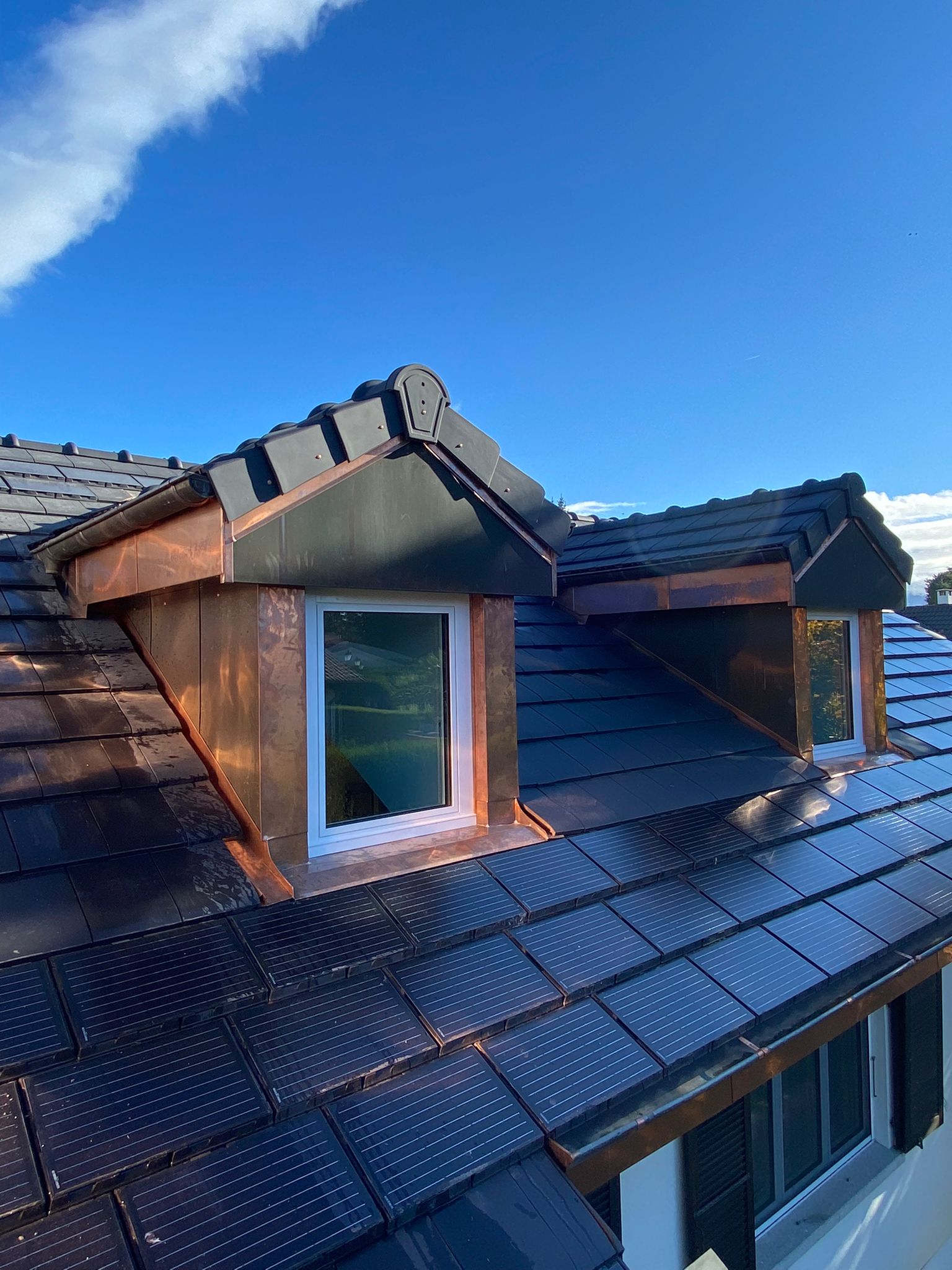 Un toit avec une fenêtre dessus et un ciel bleu en arrière-plan.