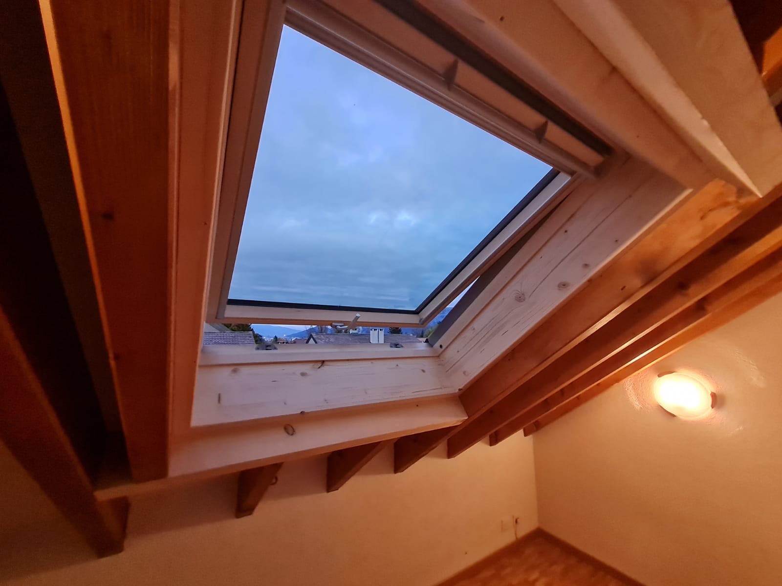 Regardant vers une lucarne dans une pièce avec des poutres en bois