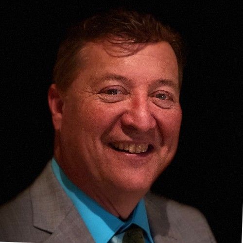 A man in a suit and tie is smiling for the camera A man in a suit and tie is smiling for the camera