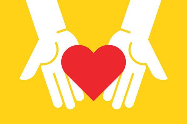A couple of hands holding a red heart on a yellow background.