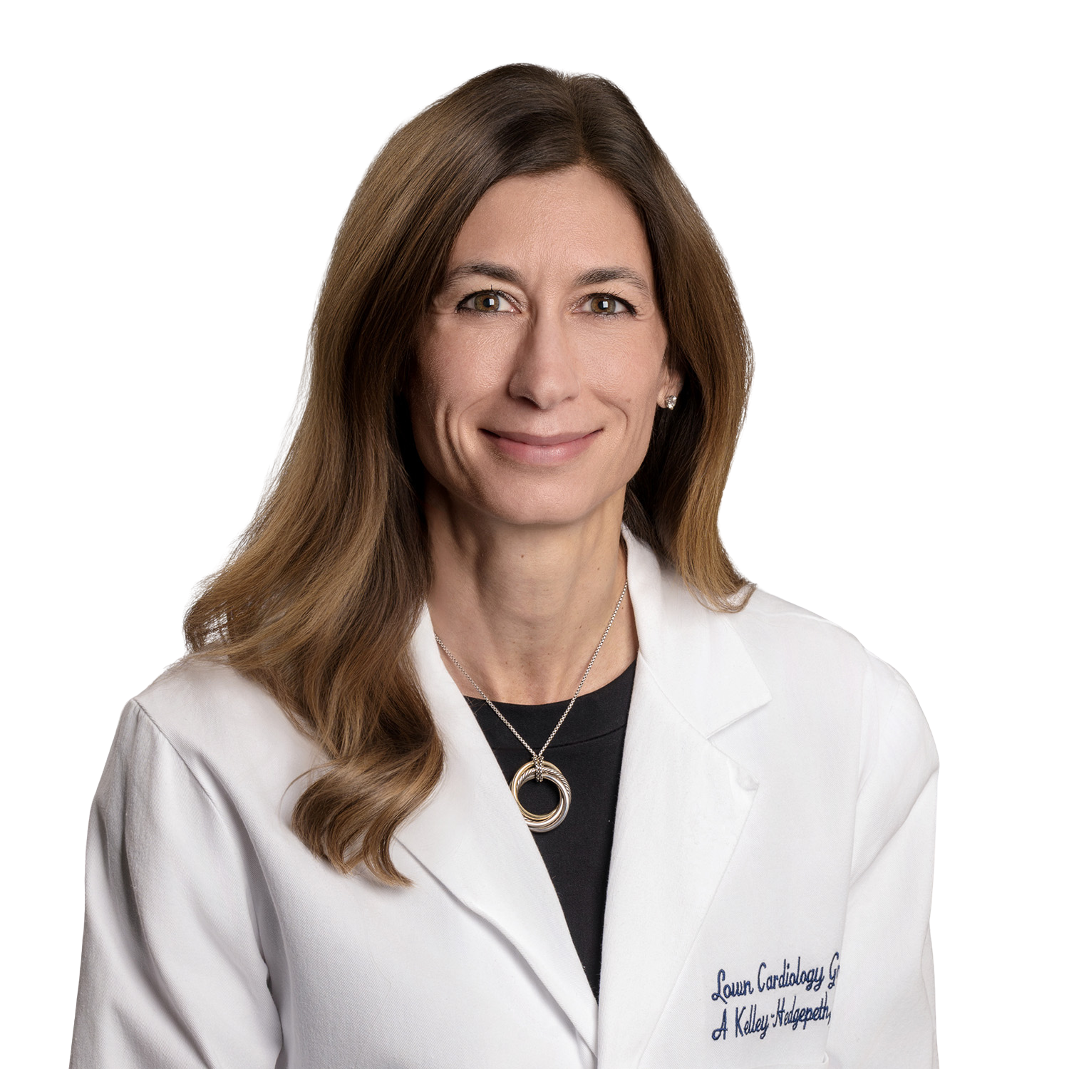 Woman in a white lab coat, smiling, wearing a necklace.