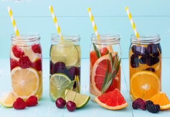 A row of mason jars filled with fruit and straws.
