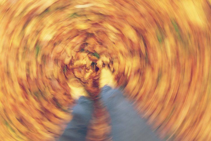 A blurry picture of a person standing in a circle of leaves.