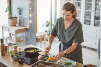 A woman is preparing food in a kitchen.