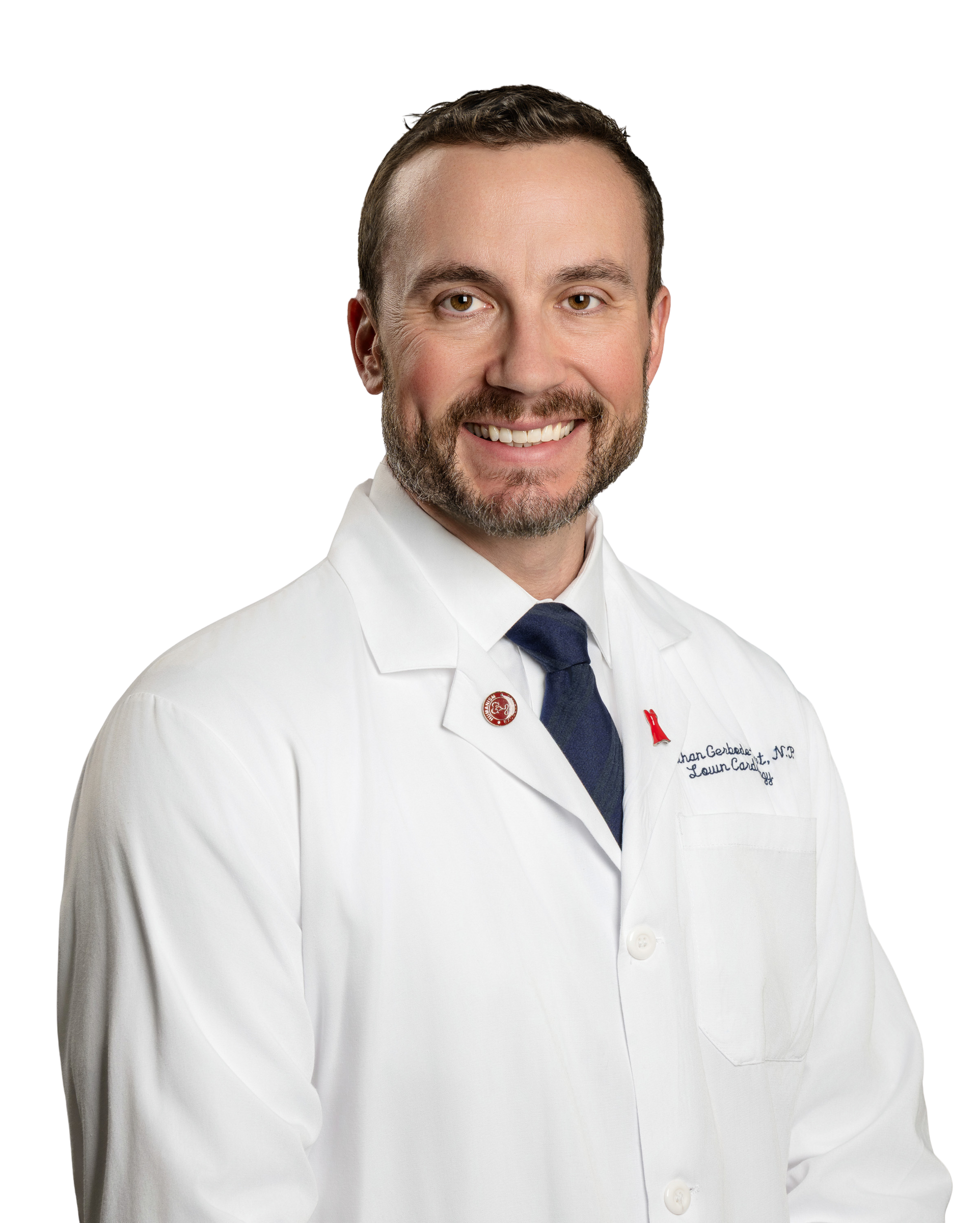 Smiling doctor in a white coat and navy tie, against a white background.