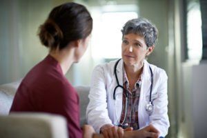 A doctor is talking to a patient in a hospital room.