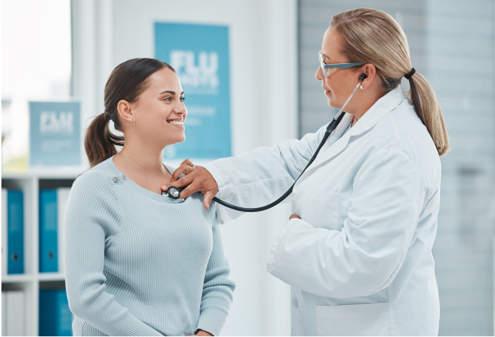 A doctor is listening to a patient 's heart with a stethoscope.