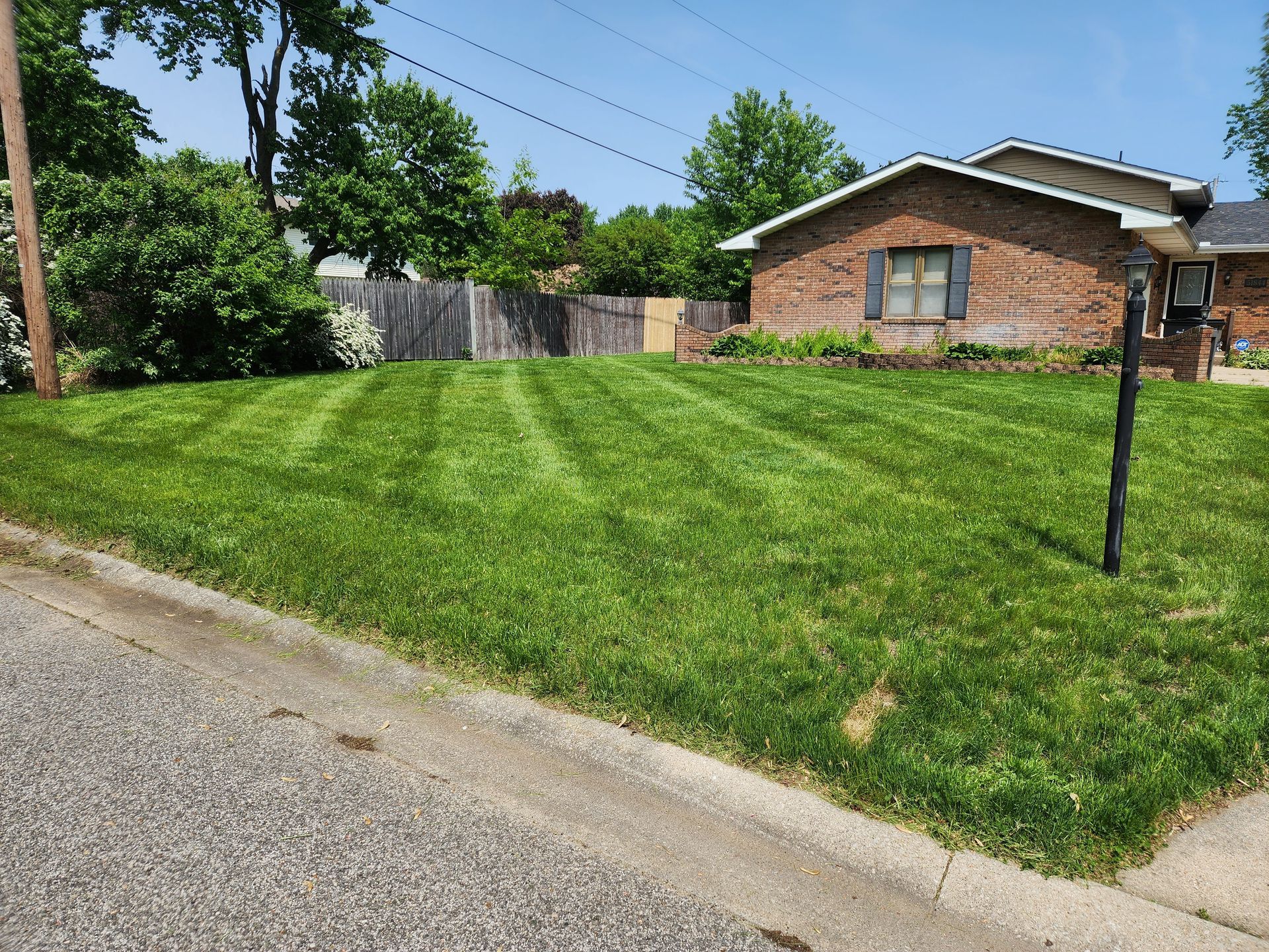 A brick house with a lush green lawn in front of it.