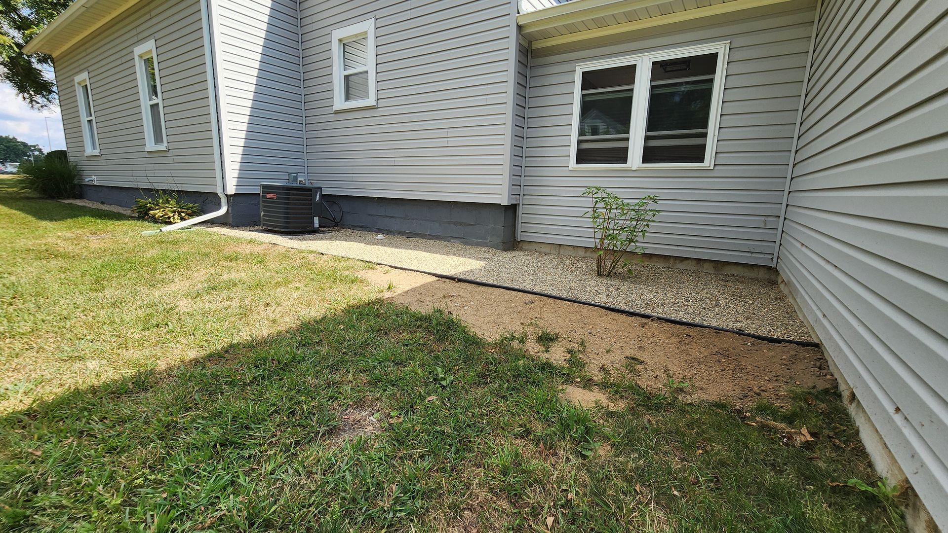 The side of a house with a walkway leading to it.