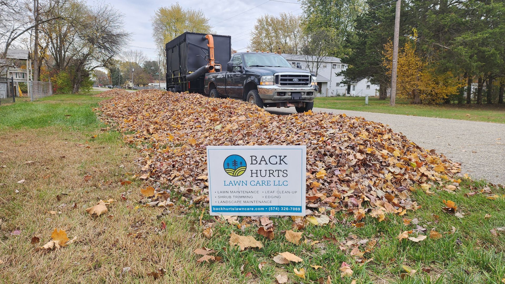 A car is parked in front of a brick house.