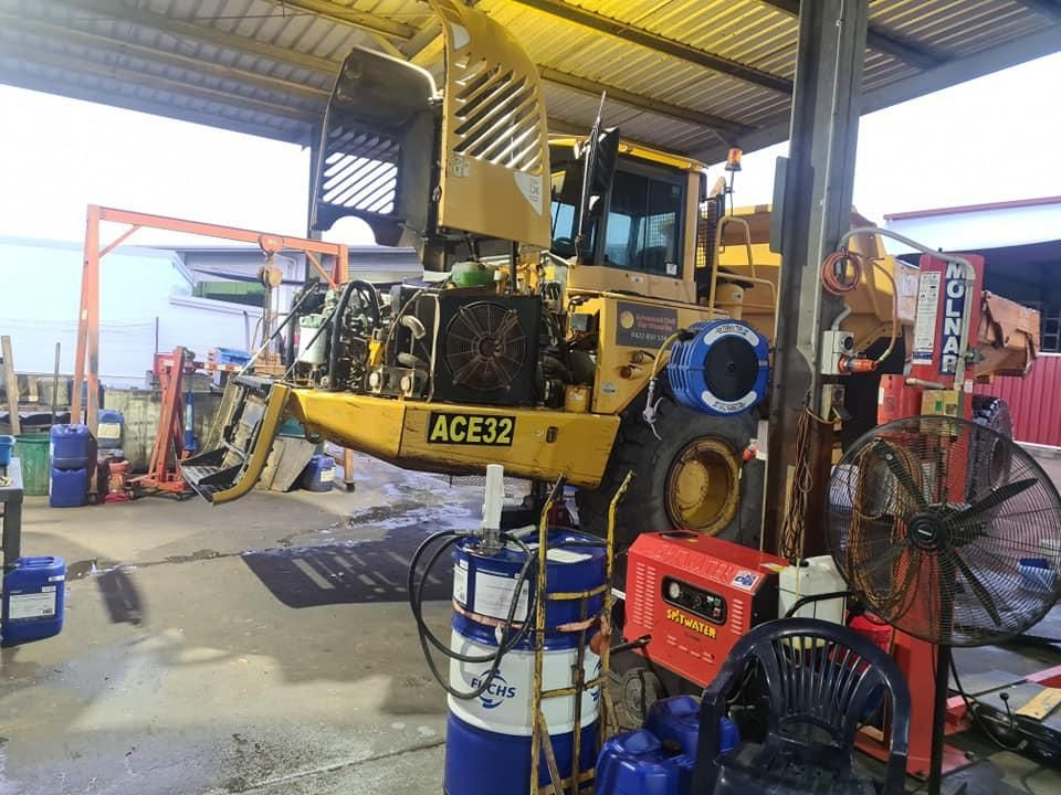 A Bulldozer is Sitting on a Lift in a Garage — Giger Machinery Services in Bentley Park, QLD