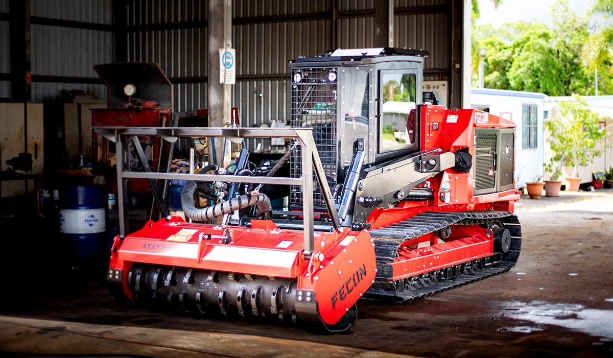 A Red and White Tractor is Parked in a Garage — Giger Machinery Services in Gordonvale, QLD