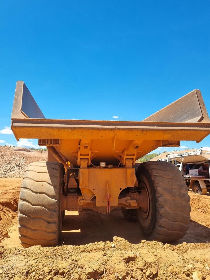 A Yellow Dump Truck With a Blue Sky in the Background — Giger Machinery Services in Bentley Park, QLD
