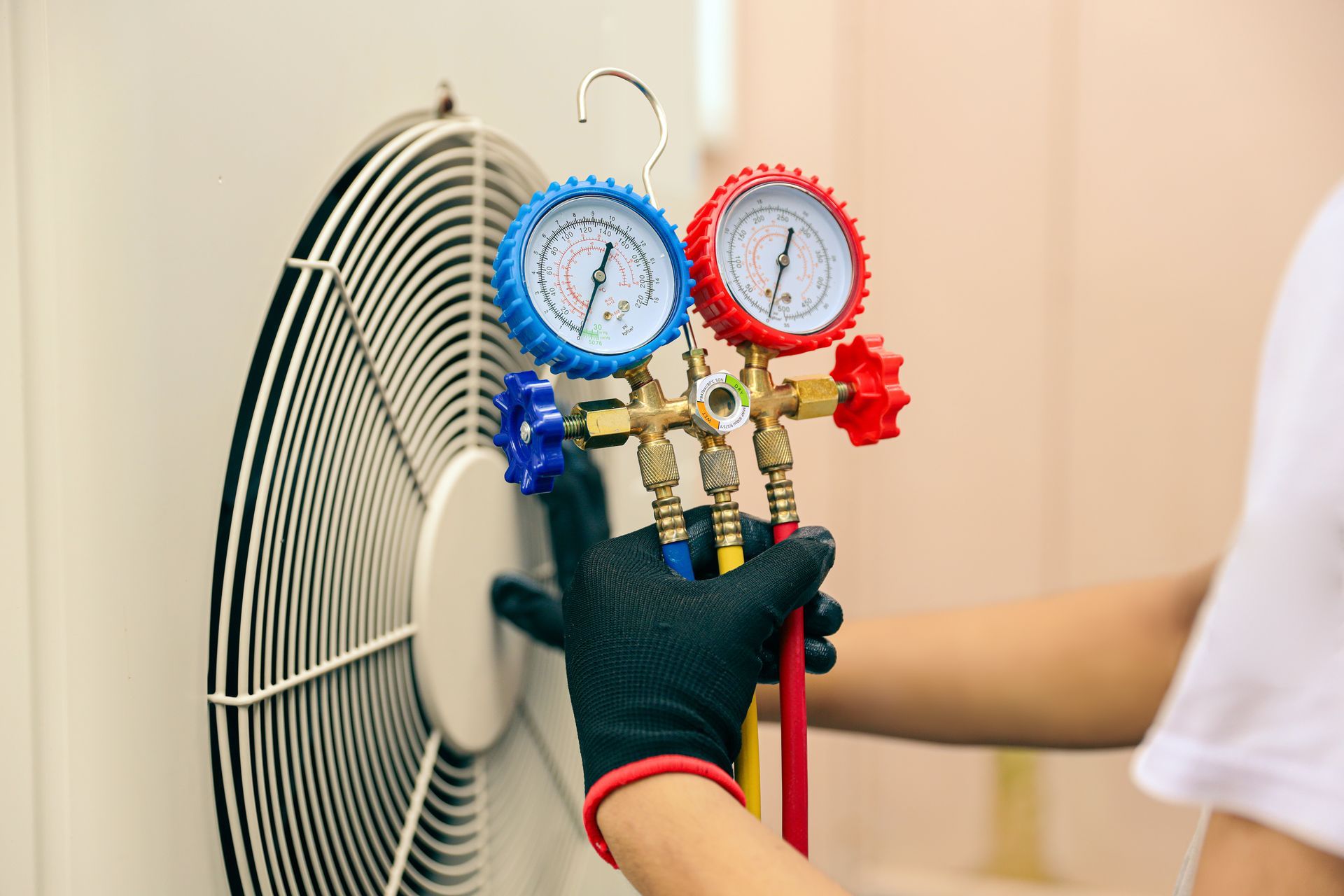 A person is holding a pair of gauges next to a fan.