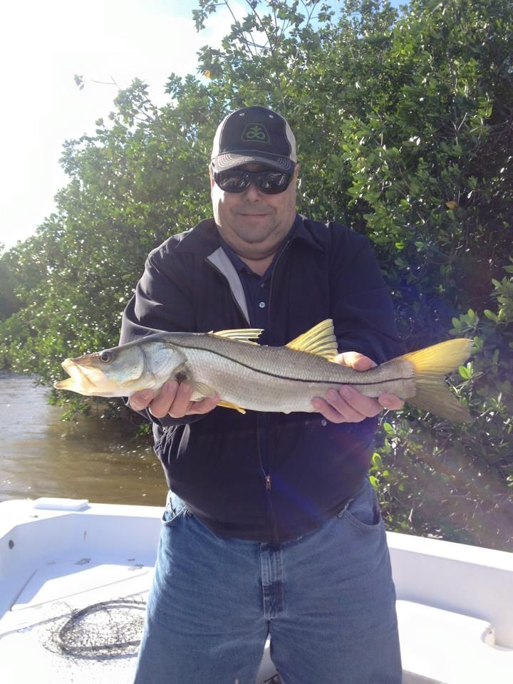 A man is holding a fish in his hands on a boat