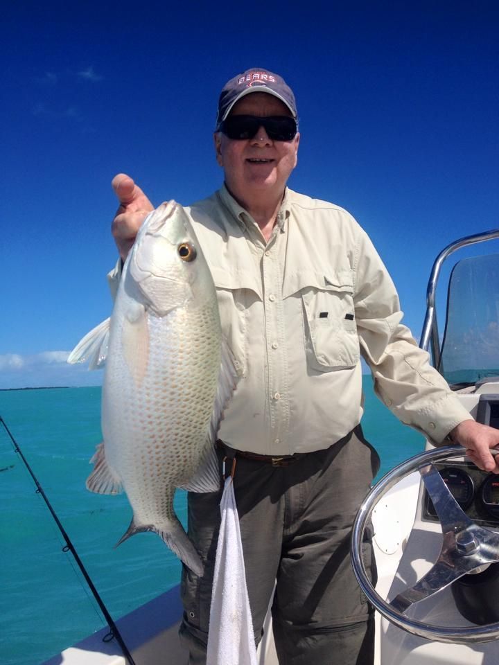 A man on a boat holding a large fish
