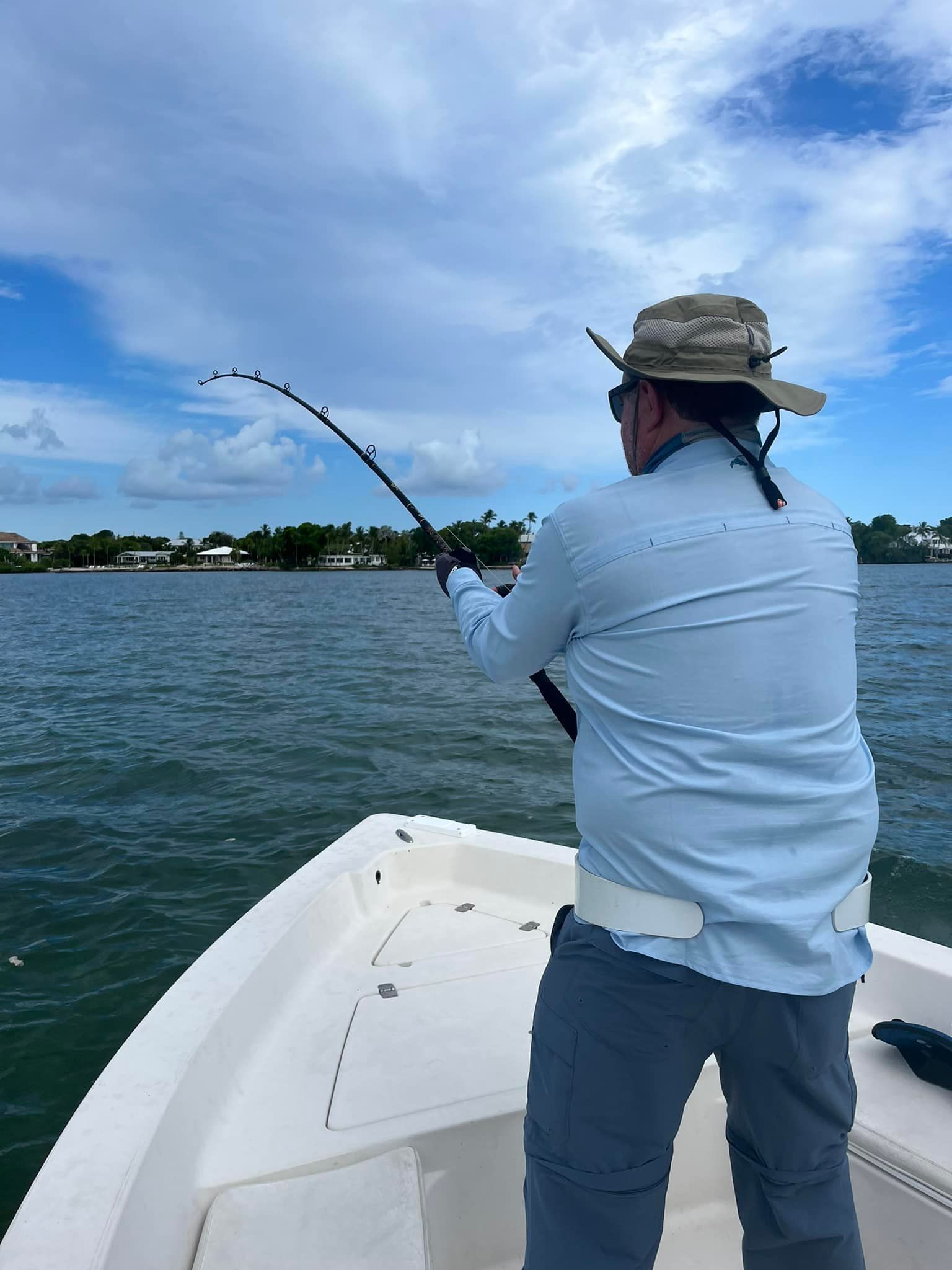 A man is fishing on a boat in the water.