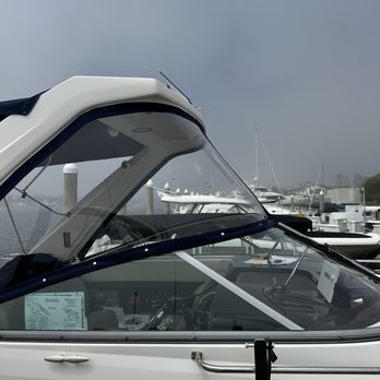 White boat cabin with clear windows, blue trim, and a cloudy sky background.