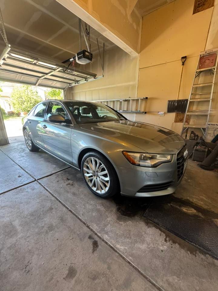 Silver Audi sedan parked inside a garage, with the garage door open.
