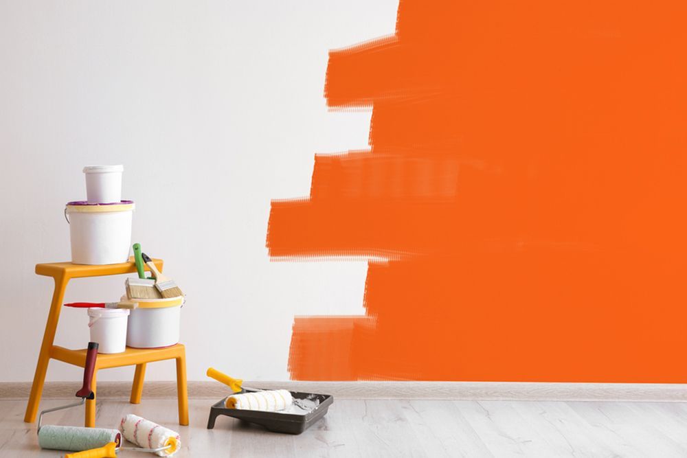 Painting tools in front of a partially painted wall — Interior Painting in Maryborough, QLD