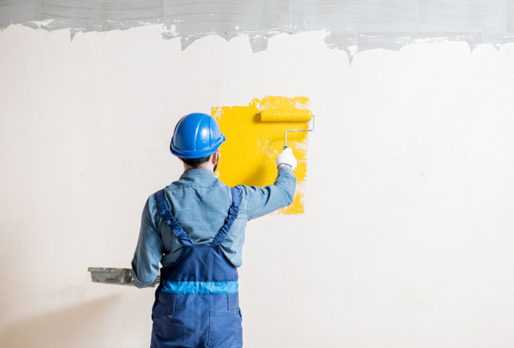 Man painting the wall yellow — Painters in Fraser Coast, QLD